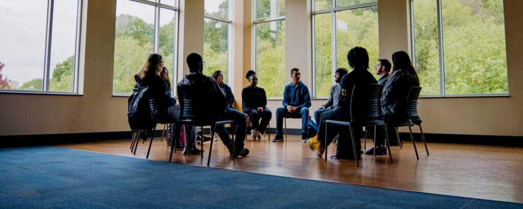 Group of ten students sitting on chair around a circle